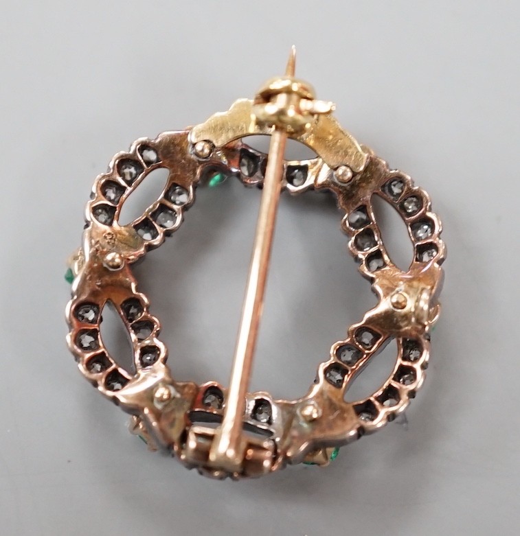 A late Victorian yellow and white metal, emerald and diamond cluster set open work brooch, 21m, gross weight 4.3 grams.